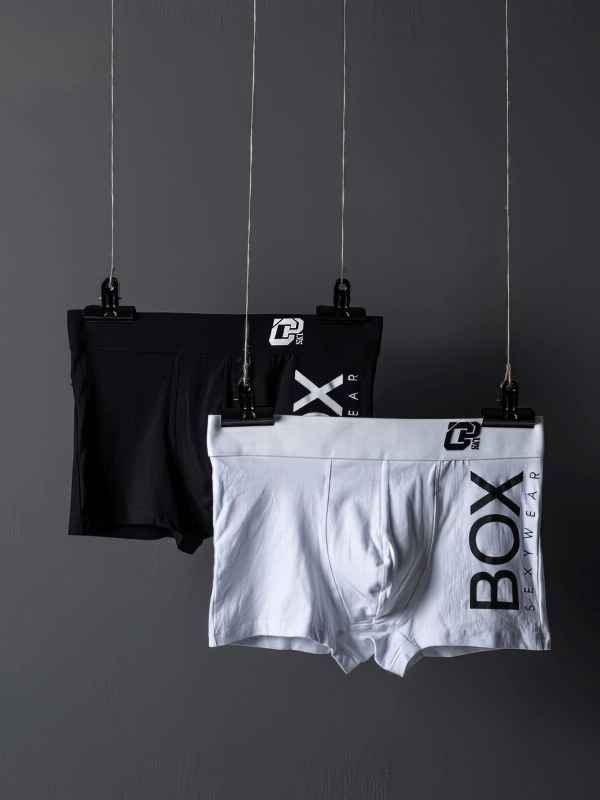 Stylish Soft Sports Men's Boxers in black and white, hung against a dark background, showcasing sleek design and comfort by SF0727.